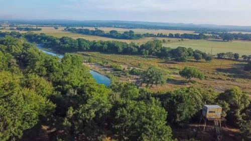 an aerial view of a river in a field at The Camp Blanco by Lodgewell - Riverfront retreat 2 Homes, Bunk House, Game Room & more in Blanco