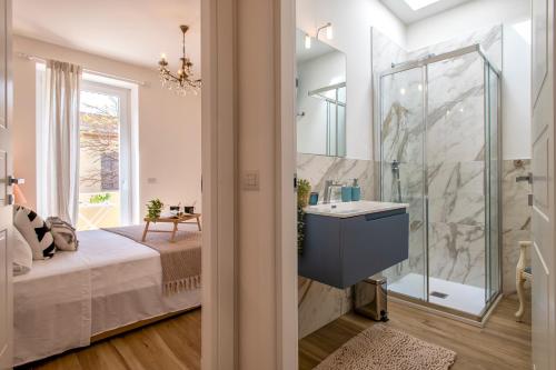 a bathroom with a sink and a glass shower at Delia's Home in Alghero