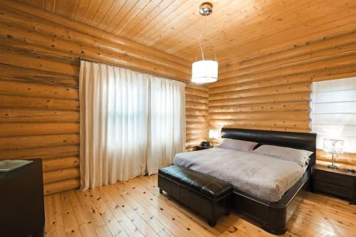 1 dormitorio con 1 cama y pared de madera en Fiddler Lake Resort Chalet Deer 59 en Mille-Isles