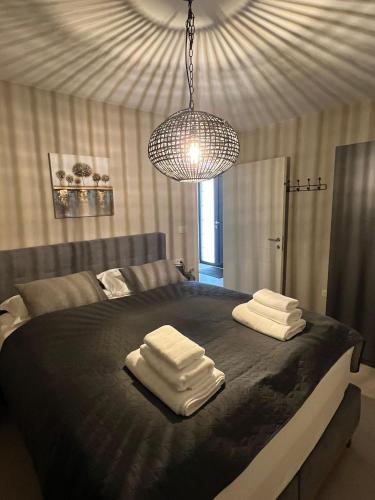 a bedroom with a bed with towels on it at Villa Vinova Loza in Kaštelir