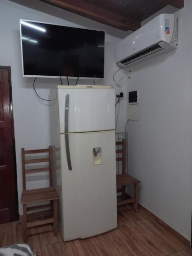 Habitación con nevera blanca y TV de pantalla plana. en FERISADU en Puerto Iguazú