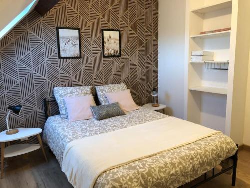 une chambre avec un lit avec des oreillers roses dessus dans l'établissement Joli appartement en duplex neuf à Saint-Josse, à Saint-Josse