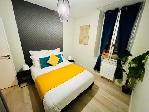 a bedroom with a bed with yellow and blue pillows at LA PALME 50 m de la plage en baie de Somme in Cayeux-sur-Mer