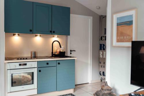 une cuisine avec des armoires bleues et un évier dans l'établissement Cozy apartment by the sea, à La Teste-de-Buch