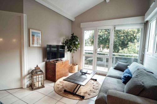 un salon avec un canapé et une table dans l'établissement Cozy apartment by the sea, à La Teste-de-Buch