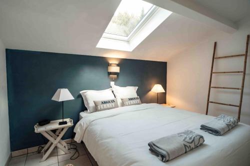 - une chambre avec un grand lit blanc et une lucarne dans l'établissement Cozy apartment by the sea, à La Teste-de-Buch
