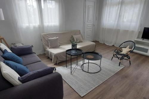 un salon avec un canapé et une table dans l'établissement Pin Pon d'Or, petite maison proche de la plage, à Andernos-les-Bains