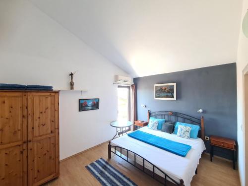 a bedroom with a bed with blue sheets and a window at Apartments Helena Pomer in Pomer
