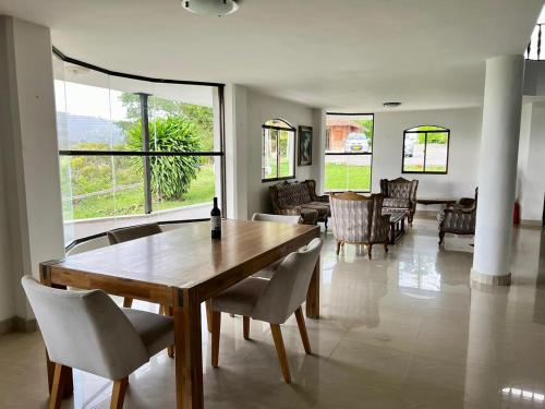 een woonkamer met een houten tafel en stoelen bij Finca Calimita in Calima