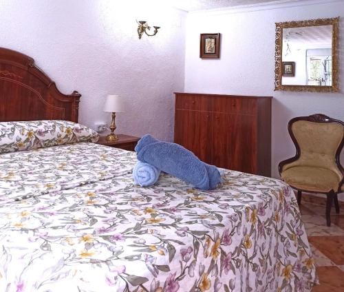 un animal de peluche azul en una cama en un dormitorio en El Azahar en Sevilla