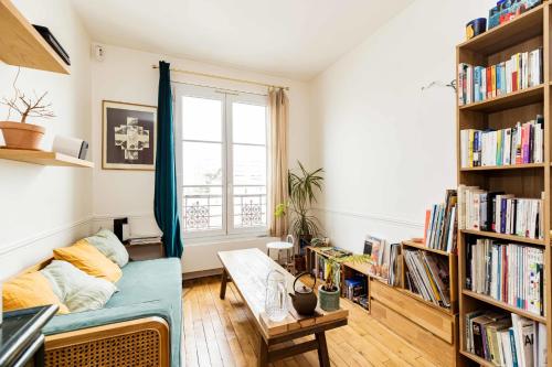 ein Wohnzimmer mit einem Sofa und Bücherregalen in der Unterkunft Luminous cocoon near Paris in Bagnolet