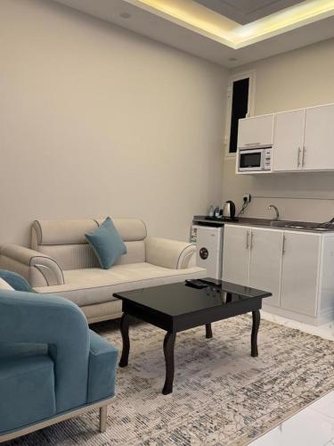 a living room with a couch and a table at ضيف بارك للشقق المخدومة in Ad Dawādimī