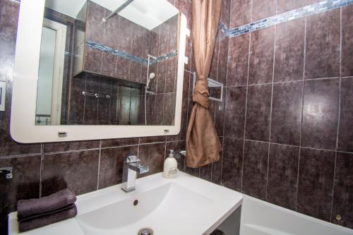 une salle de bain avec un lavabo et un miroir dans l'établissement Cosy 1 BDR Kremlin-Bicêtre (2 min Porte d'Italie), au Kremlin-Bicêtre