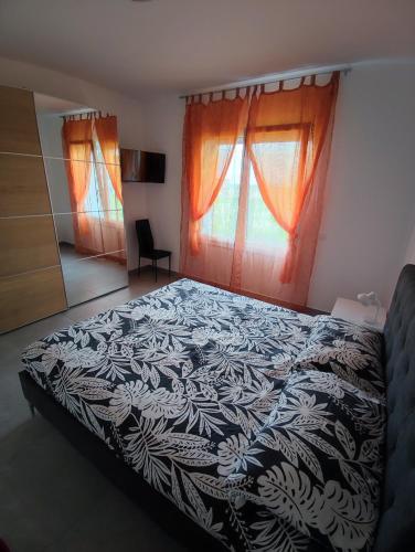 una camera da letto con un letto bianco e nero con due finestre di Villa Emily appartamento a Ca Tiepolo