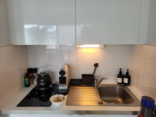 a kitchen with a sink and a counter top at Le raffiné - Studio avec balcon, proche de l'océan in La Baule