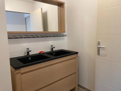 a bathroom with a black sink and a mirror at A 15km du Mont-Saint Michel in Saint-James