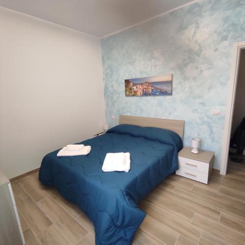 a bedroom with a blue bed with two towels on it at Onda Marina 2 in La Spezia