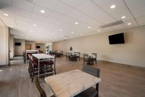 a waiting room with tables and chairs and a flat screen tv at Best Western Springfield in Springfield