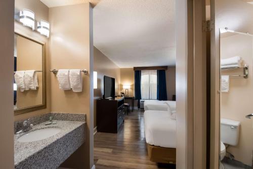 a hotel room with a bathroom with a sink and a bed at Best Western Springfield in Springfield