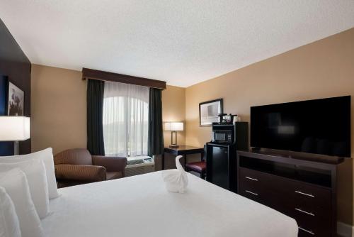 a hotel room with a bed and a flat screen tv at Best Western Springfield in Springfield