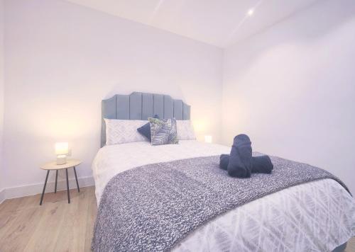 ein Teddybär sitzt auf einem Bett in einem Schlafzimmer in der Unterkunft Shaw Heath Cottage - Charming Holiday Home In the Heart of Stockport - Free Parking in Stockport