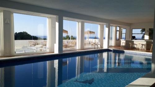 a swimming pool in a house with a view of the ocean at Victoria Sunset Suites in Port des Torrent