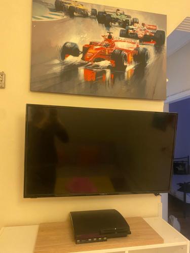 a flat screen tv on a wall with a race car on it at Queen Suites Family Friendly 60m2 in Thessaloniki