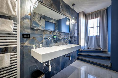 a bathroom with a sink and a blue wall at Hotel Duomo Firenze in Florence
