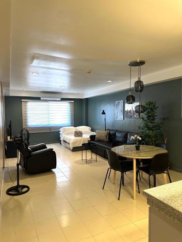 un soggiorno con un divano e un tavolo di CRIB 217 SUBIC BAY - Mediterranean Condo with Unlimited Massage a Olongapo