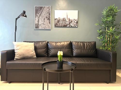 a brown couch with a table in a living room at CRIB 217 SUBIC BAY - Mediterranean Condo with Unlimited Massage in Olongapo