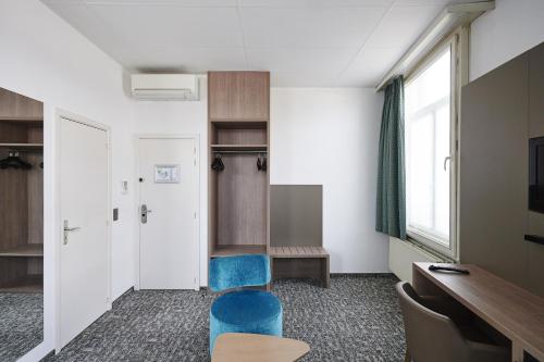 une salle d'attente avec des chaises bleues et un bureau dans l'établissement Grand Hotel de Flandre, à Namur