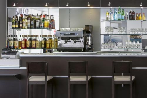 a bar with two chairs and a coffee maker at Best Western Hôtel des Thermes - Balaruc les Bains Sète in Balaruc-les-Bains