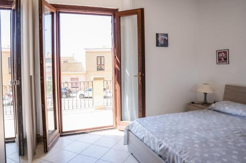 - une chambre avec un lit et une porte coulissante en verre dans l'établissement Casa Graziosa, à Nurachi