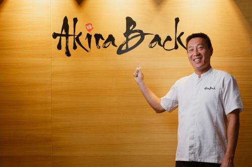 a man standing in front of a sign that says happy bar at The Ritz-Carlton Tenerife, Abama in Guía de Isora