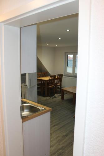 a kitchen with a sink and a table with chairs at Ferienhaus Kunz in Fehmarn