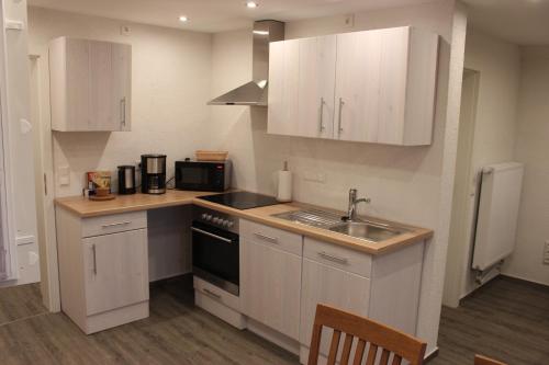 a kitchen with white cabinets and a sink at Ferienhaus Kunz in Fehmarn