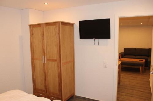 a bedroom with a cabinet and a television on a wall at Ferienhaus Kunz in Fehmarn