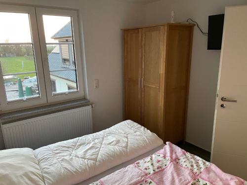 um quarto com uma cama, uma cómoda e uma janela em Ferienhaus Kunz em Fehmarn