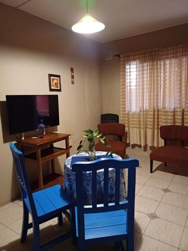 sala de estar con mesa, sillas y TV en Beltrán Temporario en Neuquén