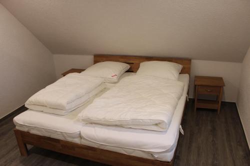 a bedroom with two beds with white blankets and pillows at Ferienhaus Kunz in Fehmarn
