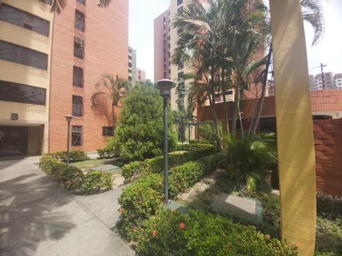 a street light next to a building with trees and bushes at Apartamento Maracay Base Aragua in Maracay