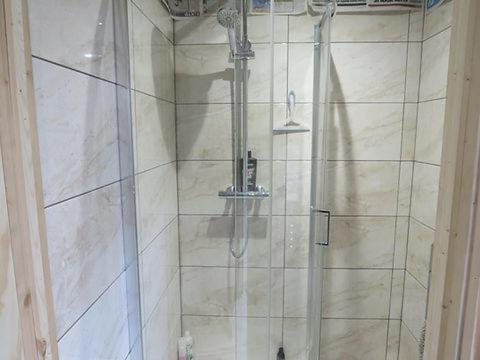 een douche met een glazen deur in de badkamer bij Hillside in Llanelli