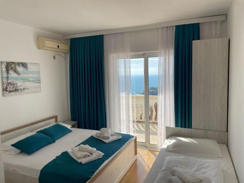 1 Schlafzimmer mit 2 Betten und einem großen Fenster in der Unterkunft Molla Apartments in Ulcinj