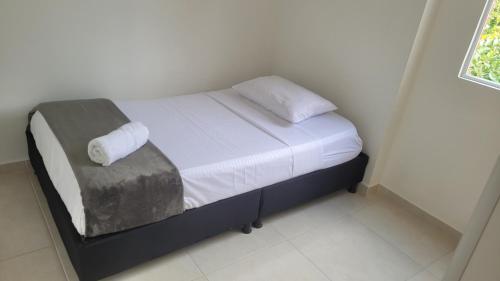 a bed with two pillows on it in a room at Apartamento en la Samaria - Ibagué in Ibagué