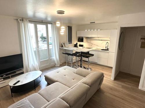 uma sala de estar com um sofá e uma cozinha em Duplex + balcon proche centre em Grenoble