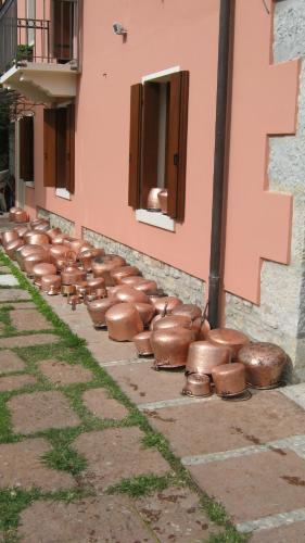 a row of copper pots on the side of a building at La Residence da Caterina in Vittorio Veneto
