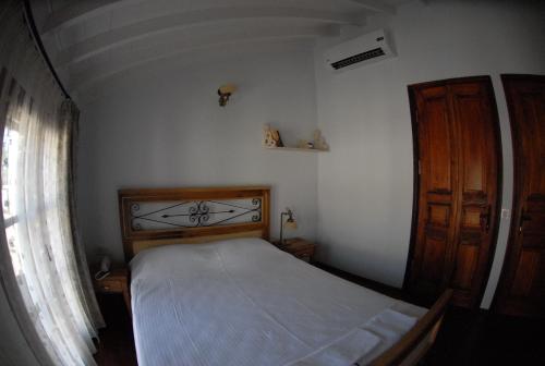 a small bedroom with a bed and a window at Aliye Hanim Hotel in Ayvalık