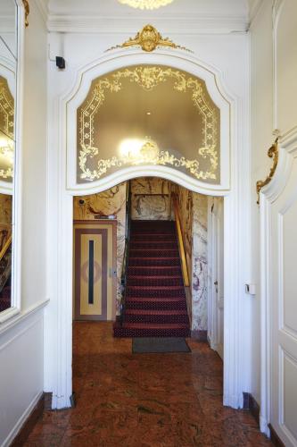a staircase in a building with a gold ceiling at Grand Hotel de Flandre in Namur