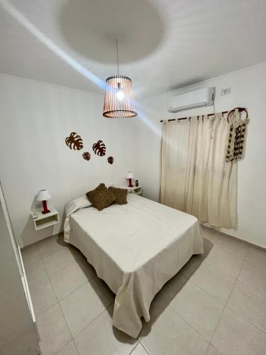 a bedroom with a bed with a light on the ceiling at Departamentos FAVE in Esperanza