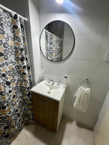 a bathroom with a sink and a mirror at Departamentos FAVE in Esperanza